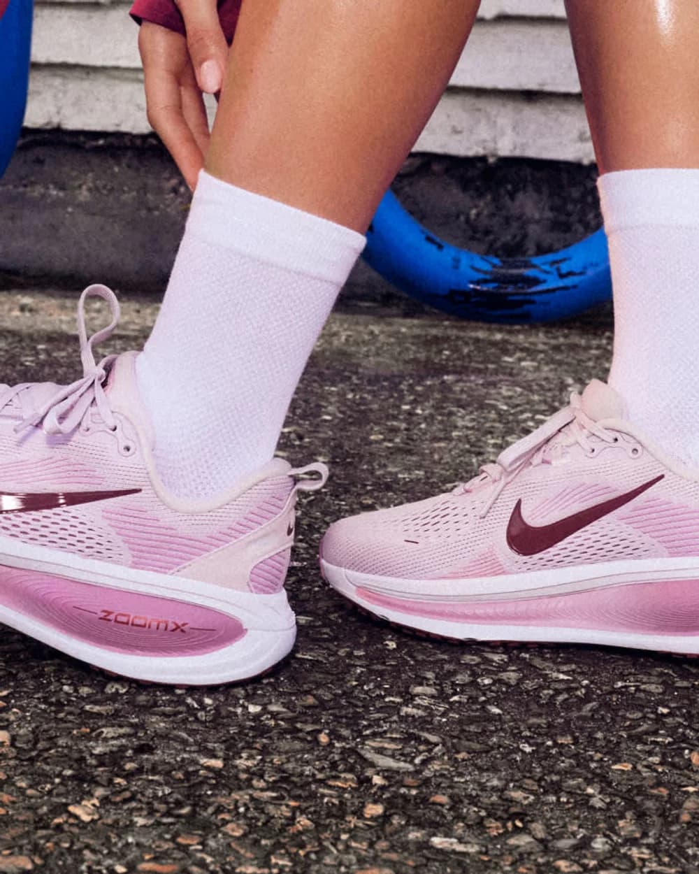 Pés de meia branca com um par de Nike de corrida rosa, de perto